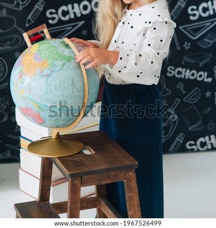 girl put her hand on the globe. School, education and travel theme.