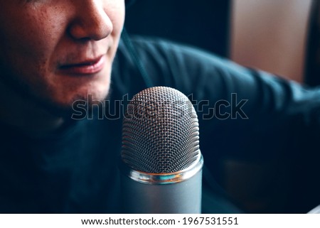 The guy is live on the Internet or radio. Part of face and microphone. Retro old microphone. Radio show or audio podcast concept.