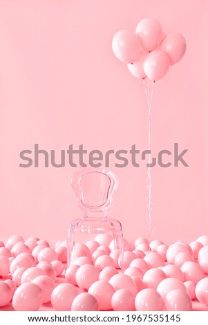 Empty transparent chair on pink pastel background among pink air balloons. Celebration, decor, creative concept