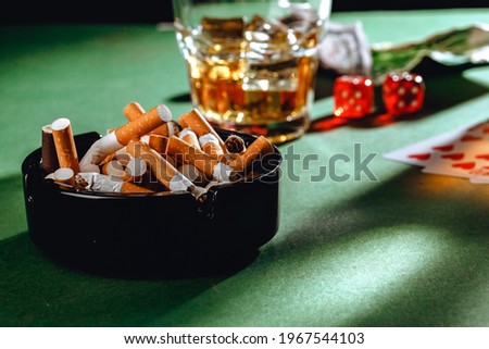Playing poker with whiskey and cigars on table