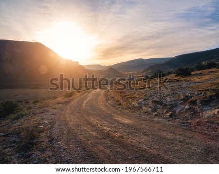 Morning dirt road through the mountain plateau. Royalty-Free Stock Photo #1967566711