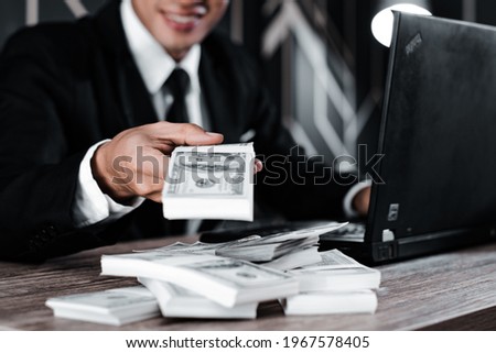 Selective focus. Close up of businessman hand offering batch of hundred dollar bills.Venality, bribe, corruption concept.  Royalty-Free Stock Photo #1967578405