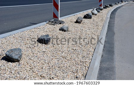 There are a number of gray stones between the lanes as protection against crossing a pebble bed. transport solutions at the parking lot