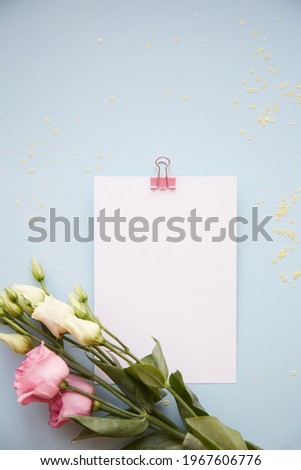 Summer background: Stationery card with eustoma flowers close up on blue background. Copy space. Beauty concept. High quality photo