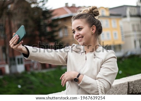 Happy girl takes a selfie on the street.