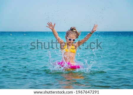 The child splashes water in the sea. Selective focus. Kid.