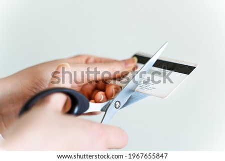 Woman cuts credit card with scissors. Royalty-Free Stock Photo #1967655847