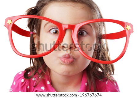 Funny little girl with big red glasses making face