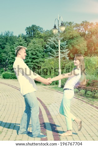 Young couple in love walking in the autumn park holding hands looking in the sunset. Hipster Style. Pictures in warm colors 