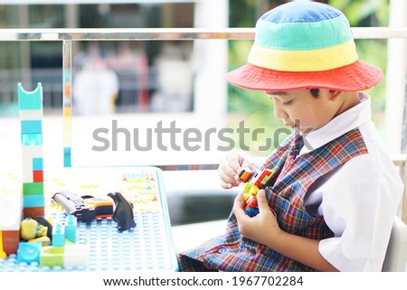 Cute Asian boy about 3 years old wearing a school uniform. Happy face. kid play the toys Practice thinking and enhancing the development of childhood. education concept.                               
