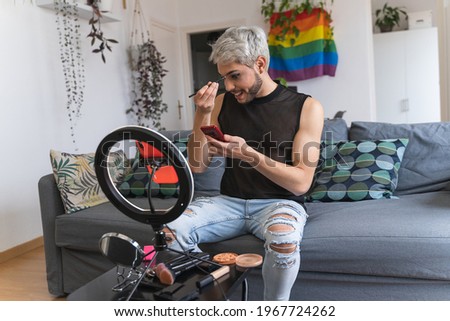 Blonde-haired gay latin guy performing makeup streaming