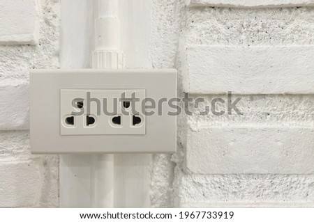 double socket plug with white brick wall background