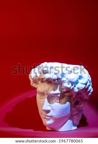 Plaster pot in the form of David's head on a red background.