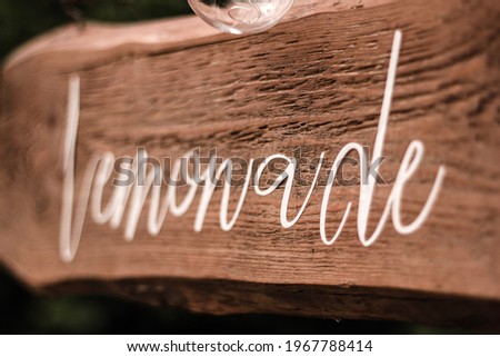 Lemonade written on a wooden board.  White letters