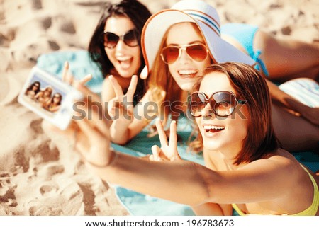 summer holidays, vacation and beach concept - girls taking selfie on the beach