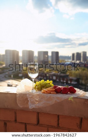 Сhilled white wine in a glass on the balcony at sunset. cozy evening on the terrace. Summertime relax on the sunny patio. 
