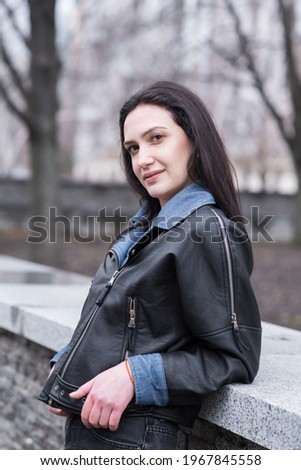 Portrait of a beautiful brunette girl who poses while walking on the street