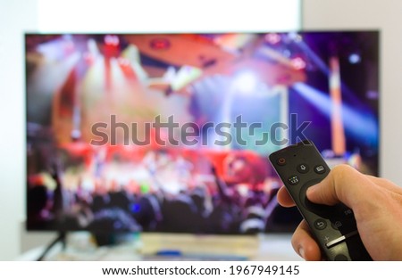 caucasian male watching television resting in the bed and switching channels virtual gig concert horns up live