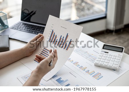 A business finance woman is reviewing a company's financial documents prepared by the Finance Department for a meeting with business partners. Concept of validating the accuracy of financial numbers. Royalty-Free Stock Photo #1967978155