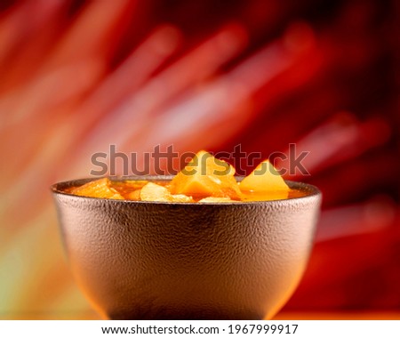 Vegetable stew in a ceramic bowl against a red and yellow background