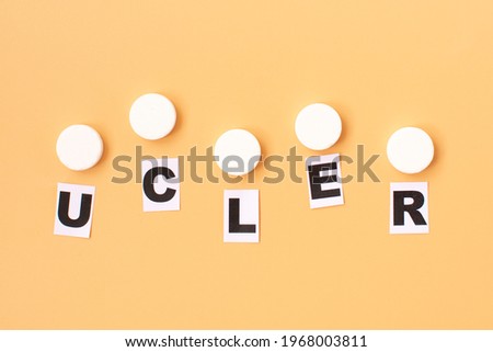 The word ulcer is written on paper among the pills. Medical concept