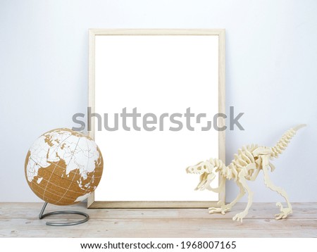 Frame with globe and dinosaur jigsaw puzzle on a wooden table