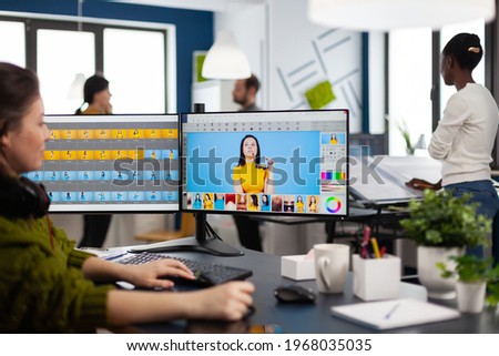 Freelancer retoucher woman working on computer with photo editing software. Professional graphic editor retouching assets of client with stylus pencil and two monitors in creative multimedia company