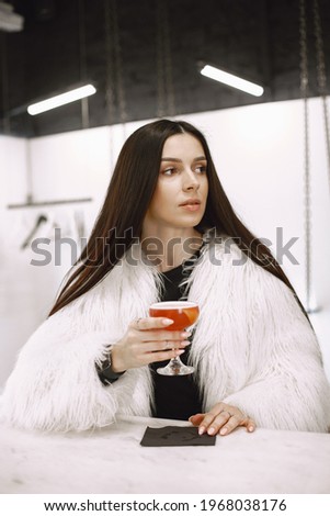 Girl drinking a red cocktail in a cafe
