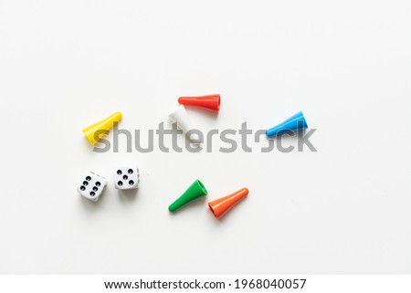 Multi-colored playing chips and dice cubes are grouped together on a white background: the concept of Board games, entertainment, background, games at home for the whole family
