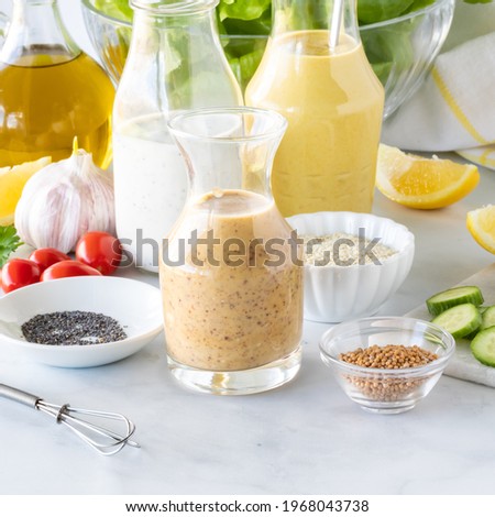 Close up of homemade salad dressings including honey mustard, poppyseed and turmeric tahini.