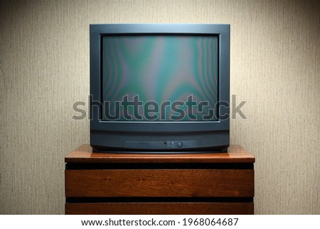 Vintage TV on wooden antique closet, old design in a home.Old black vintage TV. Royalty-Free Stock Photo #1968064687