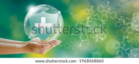 Hand offer medical shield on green background with butterfly and chemical formulas. Family life insurance, Medical care insurance, and Business healthy concepts.
