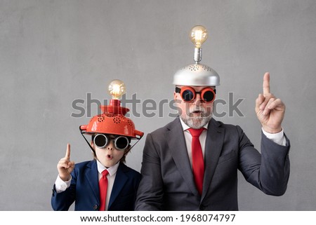 Funny child and senior man pretend to be businessmen. Grandfather and kid playing at home. Education, start up and business idea concept