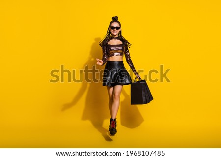 Photo of sweet adorable dark skin woman dressed glamour clothes glasses jumping shopping isolated yellow color background