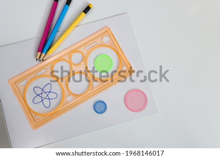 Spirograph ruler on white background. Drawing the spirograph pattern on white paper. 