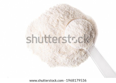 Heap of white protein powder with measuring spoon isolated on white background. Royalty-Free Stock Photo #1968179536