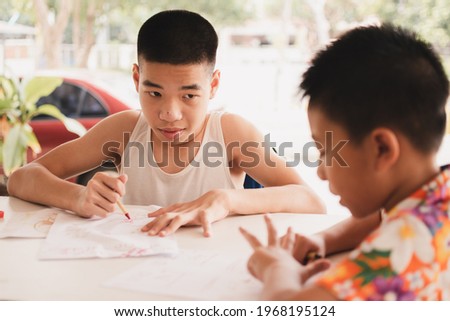 Excited emotion face of disabled child on wheelchair and his friend with indoor activity at home, Competition picture, Lifestyle of disability kid learning in homeschool doing math exercises.