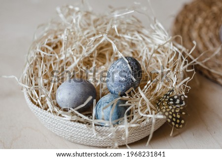 Painted Easter eggs lie in straw plate. empty space for text