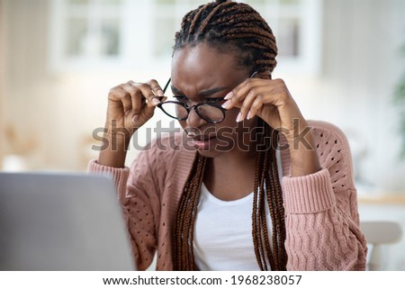 Eyesight Problems. Black Lady In Glasses Squinting While Looking At Laptop Screen, Millennial Freelancer Lady Having Eye Vision Troubles While Working Remotely With Computer At Home, Closeup Royalty-Free Stock Photo #1968238057