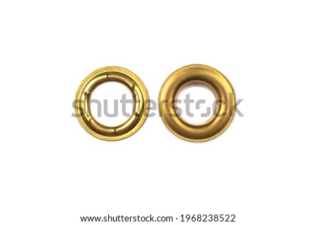 Catalogue photo of brass multicoloured metal eyelets or rivets - curtains rings for fastening fabric to the cornice, isolated on white background with copyspace for text. Selective focus