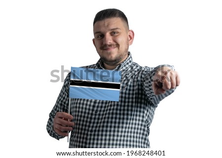 White guy holding a flag of Botswana and points forward in front of him isolated on a white background.