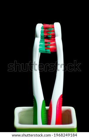red and green toothbrushes on black background