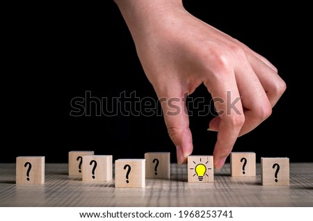 Creative idea and innovation concept. Handpicked wooden cube block light bulb icon with question icon. Royalty-Free Stock Photo #1968253741