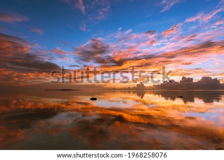 Breathtaking sunrise full of colorful clouds mirrored on the smooth ocean surface. Iriomote Island, natural world heritage.  Royalty-Free Stock Photo #1968258076