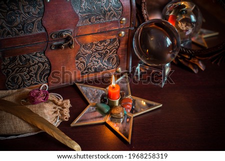 A fortune teller, witch stuff on a table, candles and fortune-telling objects. The concept of divination, astrology and esotericism Royalty-Free Stock Photo #1968258319