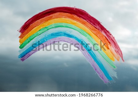 Image of a rainbow on a window during a thunderstorm. A sign of hope. Stay at home during coronavirus pandemic concept.