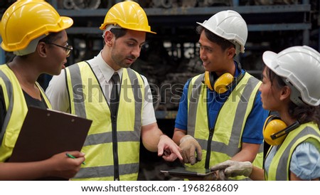 group of diversity warehouse worker meeting and checking list inventory in industry factory . eastern manager, african american clerk clipboard , asian man using tablet . teamwork of multiethnic Royalty-Free Stock Photo #1968268609