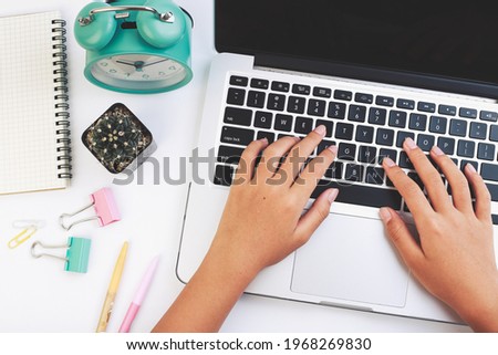 Top view hands of child on table desk white background,computer keyboard and other office supplies. Top view with copy space, flat lay.