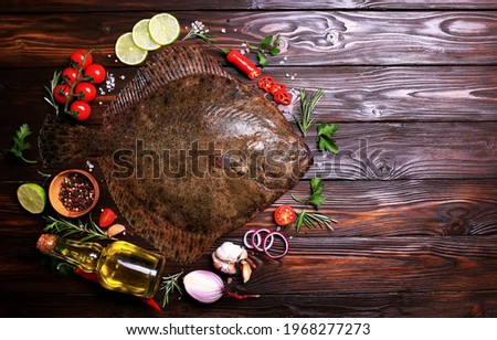 Halibut fish on wood background with spices and vegetables