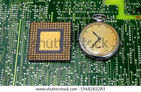 computer chip and pocket watch on circuit board 